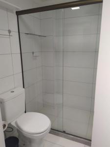een badkamer met een toilet en een glazen douche bij Laguna Beach Flat in Porto De Galinhas