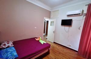een slaapkamer met een bed met een knuffeldier erop bij Joya Apartmento in Caïro