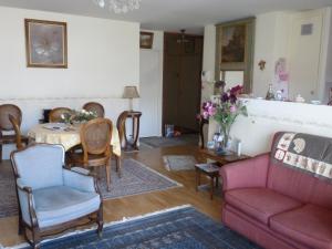 a living room with a couch and a table and chairs at Appartement Alésia - Plaisance in Paris