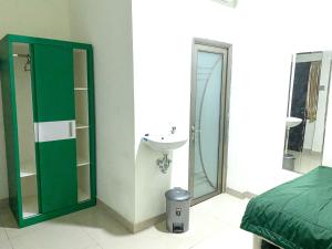 un bagno con lavandino, water e specchio di Anugrah Inn a Nalagat