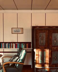 salon z krzesłem i półką na książki w obiekcie Stern B&B & Suite Apartments w mieście Nova Levante