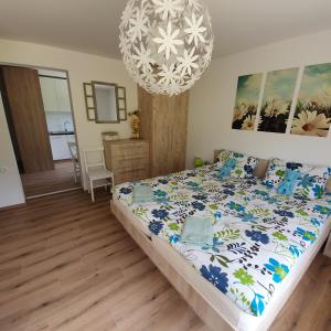 a bedroom with a bed and a chandelier at Apartma Rožle in Mojstrana