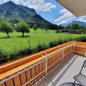 a balcony with a view of a field and mountains at Apartma Rožle in Mojstrana