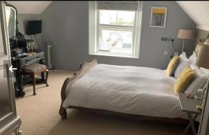 a bedroom with a large white bed and a window at The White House Hotel in Newquay