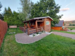 eine kleine Hütte in einem Hof neben einem Zaun in der Unterkunft Chata pod Dębem in Ryczów