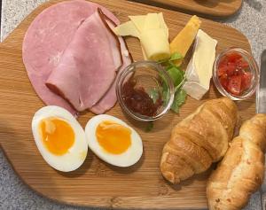 a wooden cutting board with eggs eggs bread and meats at The White House Hotel in Newquay