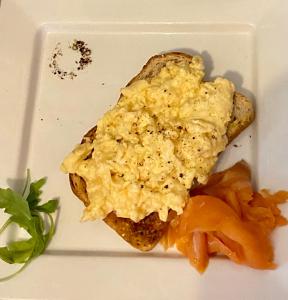 a white plate with a piece of bread with eggs on it at The White House Hotel in Newquay
