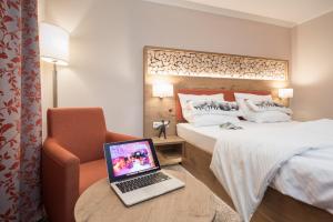 a hotel room with a laptop on a table next to a bed at Hotel Pension Fortuna in Bad Bevensen