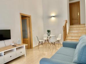 sala de estar con sofá azul y mesa en Apartamento dúplex en el centro de Huesca, en Huesca