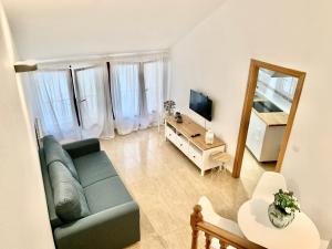 sala de estar con sofá azul y TV en Apartamento dúplex en el centro de Huesca en Huesca