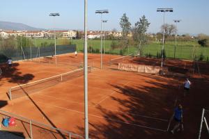 un grupo de personas jugando al tenis en una pista de tenis en Mina House, en Campi Bisenzio