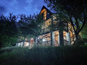 Una casa grande se ilumina por la noche en FERN FARM ECO RESORT, en Mojkovac