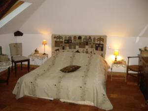 um quarto com uma cama grande e uma colcha branca em Le Beaupassant em Vihiers