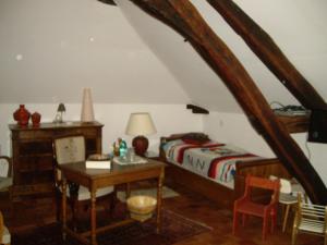 a bedroom with a bed and a desk and a table at Le Beaupassant in Vihiers