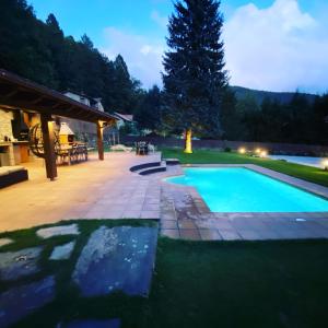 a swimming pool in a backyard at night at El Niu de l’Àguila (Camprodon) in Camprodon