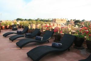 a row of chairs sitting on top of a roof at Riad Shemsi in Marrakesh