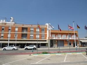 a large building with flags in front of it at Hotel Bennington in La Marina