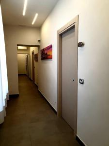 un corridoio vuoto con una porta in un edificio di QUEEN MEDINA Centro Storico a Napoli