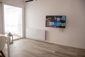 a living room with a flat screen tv on a wall at NUEVO luminoso y con terrazas junto a la playa in Sant Feliu de Guíxols