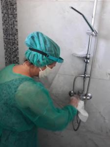 a woman in scrubs is repairing a shower at AS SUITES ROOM 14 in Rhodes Town