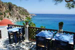 - un balcon avec deux tables et des chaises donnant sur l'océan dans l'établissement Pension Akropolis, à Kyra Panagia