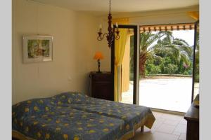 a bedroom with a bed and a sliding glass door at Lou Pei 2 Superbe vue mer Piscine chauffée 10x5m Version 3ch 3sdb in Saint-Peïre-sur-Mer