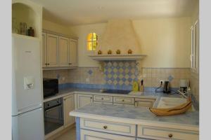 a kitchen with white cabinets and a blue counter top at Lou Pei 2 Superbe vue mer Piscine chauffée 10x5m Version 3ch 3sdb in Saint-Peïre-sur-Mer