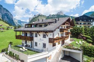 a large white building with balconies and mountains at Residence Cesa Rives in Selva di Val Gardena