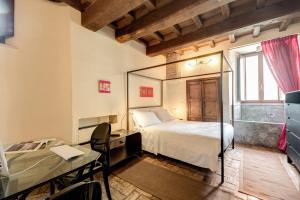 a bedroom with a bed and a desk and a mirror at Residenza Torre Colonna in Rome