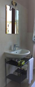 a white sink in a bathroom with a mirror at 1928 Guest House in Pogno