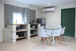 uma sala de jantar com uma mesa e cadeiras brancas em Silom Apartment Close to BTS +WIFI+Netflix em Banguecoque