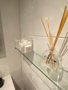 a glass shelf with a glass vase with sticks in it at The Family Tree in Whatstandwell