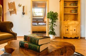einen Stapel Bücher auf einem Couchtisch im Wohnzimmer in der Unterkunft Alpenchalet St.Ulrich in Krün
