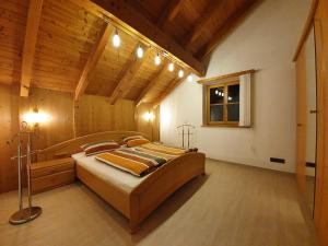 Un dormitorio con una cama grande en una habitación con techos de madera. en Ferienwohnung am Kneipp-Park en Scheidegg