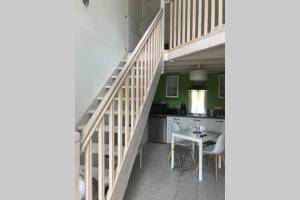 eine Küche mit einer Treppe und einem Tisch in einem Zimmer in der Unterkunft L Abricotier in Saint-Crépin