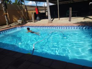 Palatswe的住宿－Bonjour Inn Palapye，在一个游泳池游泳的男孩