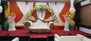 a wedding altar with a white couch and flowers at Hotel Shubhra Grand in Ghāzīpur