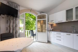 a kitchen with white cabinets and a table at Holiday Resort Balota in Viganj