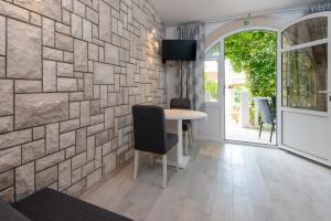 a room with a table and a stone wall at Holiday Resort Balota in Viganj