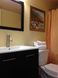 a bathroom with a sink and a toilet and a mirror at Surfsider Resort - A Timeshare Resort in Pompano Beach