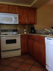 a kitchen with white appliances and wooden cabinets at Surfsider Resort - A Timeshare Resort in Pompano Beach