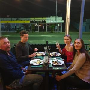 un grupo de personas sentadas alrededor de una mesa comiendo comida en Quality Hotel Regent Rockhampton en Rockhampton