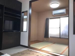Miyoshiにあるエバーガーデンの鏡、テレビ、窓が備わる客室です。