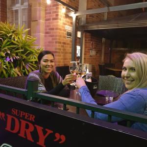 zwei Frauen sitzen an einem Tisch mit Gläsern Wein in der Unterkunft Quality Hotel Regent Rockhampton in Rockhampton