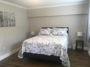 a bedroom with a bed with a floral bedspread and two lamps at Quidi Vidi Retreat 3 in St. John's