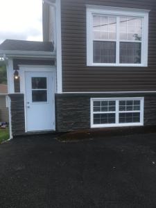 a house with a white door and two windows at Quidi Vidi Retreat 3 in St. John's