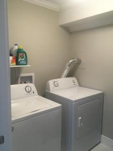 a bathroom with a washing machine and a sink at Quidi Vidi Retreat 3 in St. John's +5 photos