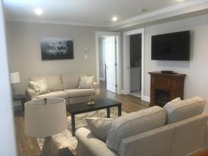 a living room with two couches and a tv at Quidi Vidi Retreat 3 in St. John's