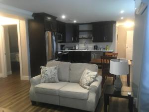 a living room with a couch and a kitchen at Quidi Vidi Retreat 3 in St. John's