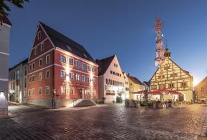 a group of buildings on a street with lights at Stadthotel Kachelofen in Krumbach